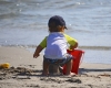 child on the beach building a sand castle